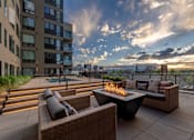 Thumbnail 1 of 21 - an outdoor patio with couches and a fire pit on a rooftop