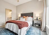 Thumbnail 7 of 42 - A bedroom with a large bed and a blue rug.