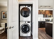 Thumbnail 9 of 42 - A white front loading washing machine in a small room.