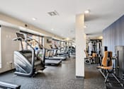Thumbnail 36 of 45 - A gym with treadmills, elliptical machines, and other exercise equipment.