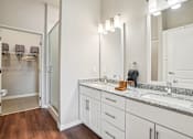 Thumbnail 13 of 42 - A bathroom with a sink, mirror, and a shower.