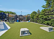 Thumbnail 41 of 46 - A playground with a green surface and two concrete structures.