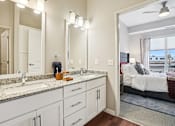 Thumbnail 8 of 42 - A bathroom with a vanity, sink, and mirror.