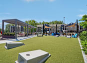Thumbnail 40 of 46 - A playground with a green surface and a wooden structure.