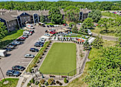 Thumbnail 27 of 46 - A park with a green lawn and a soccer goal.