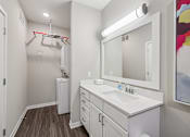 Thumbnail 18 of 49 - A bathroom with a white sink and a mirror.
