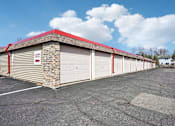 Thumbnail 18 of 24 - A parking lot with a building that has a red roof and a sign that says "No Parking".