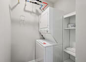 Thumbnail 19 of 49 - A white washing machine in a small laundry room.