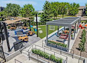 Thumbnail 28 of 46 - A patio area with a table and chairs and a green building.