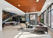 Thumbnail 22 of 45 - A modern living room with a wooden ceiling and a staircase.