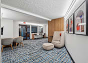 Thumbnail 36 of 46 - A conference room with a carpeted floor and a white wall with framed artwork.