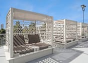 Thumbnail 11 of 40 - A white outdoor seating area with a lattice design.