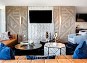Thumbnail 8 of 21 - a living room with couches and tables and a television