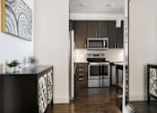 Thumbnail 10 of 21 - a kitchen with stainless steel appliances and dark wood cabinets