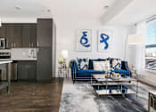 Thumbnail 11 of 21 - a living room with a blue couch and a coffee table