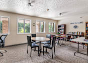 Thumbnail 20 of 24 - a classroom with tables and chairs and a library