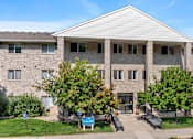Thumbnail 23 of 24 - a brick apartment building with trees in front of it