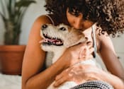Thumbnail 4 of 24 - a woman kissing a dog on a bed