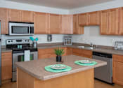 Thumbnail 4 of 11 - Kitchen with Wood Cabinets and Island