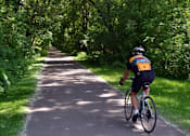 Thumbnail 15 of 24 - a person riding a bike down a path