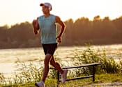 Thumbnail 4 of 24 - a man running next to a body of water