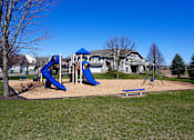 Thumbnail 24 of 24 - Community playground located on the property for time playing outside. Playground features two slides, a swing set, and multiple options of bench seating along the perimeter.