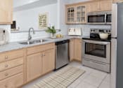 Thumbnail 2 of 24 - a kitchen with wooden cabinets and stainless steel appliances