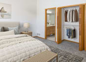 Thumbnail 20 of 24 - a bedroom with a large bed and a bathroom in the background