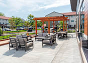 Thumbnail 24 of 30 - A patio with chairs and a pergola.