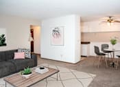Thumbnail 1 of 16 - a living room with a couch a table and a ceiling fan