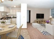 Thumbnail 2 of 16 - a living room with a table and chairs and a kitchen in the background