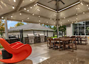 Thumbnail 24 of 28 - a patio with tables and chairs and a grill