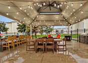 Thumbnail 25 of 28 - a patio with a table and chairs under a canopy