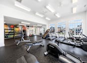 Thumbnail 21 of 30 - A gym with a variety of equipment including treadmills, weights, and exercise machines.