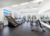 Thumbnail 20 of 30 - A gym with treadmills, exercise bikes, and other equipment.