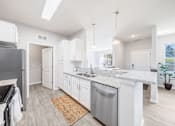 Thumbnail 8 of 30 - A modern kitchen with a stainless steel dishwasher and white cabinets.