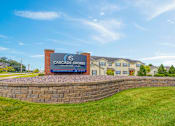 Thumbnail 30 of 30 - A sign for Cascade Shores Apartments is in front of a building.