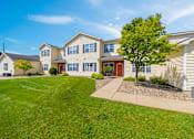 Thumbnail 1 of 30 - A large house with a red door and a tree in front.