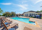 Thumbnail 4 of 30 - A sunny day at the pool with lounge chairs and a clear blue sky.