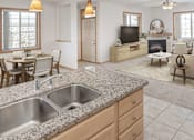 Thumbnail 2 of 27 - a kitchen with a sink and a tv in a living room