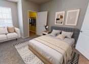 Thumbnail 9 of 27 - Spacious master bedroom complete with a large window, seating nook, and walk in closet.