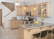 Thumbnail 1 of 27 - a kitchen with wooden cabinets and a granite countertop