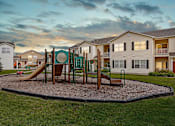 Thumbnail 22 of 27 - On site community playground against a sunset sky.