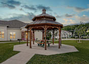 Thumbnail 23 of 27 - Private gazebo surrounded by lush green lawn with walkway leading to building.