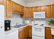 Thumbnail 2 of 13 - a kitchen with white appliances and wooden cabinets