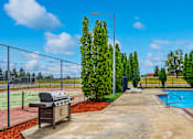 Thumbnail 9 of 13 - a grill next to a swimming pool with a chain link fence