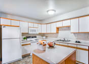 Thumbnail 2 of 20 - a kitchen with white appliances and wooden cabinets