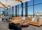 Thumbnail 11 of 24 - Sky lounge with sectional couch, pool table and large glass windows with view of Denver skyline