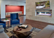 Thumbnail 26 of 30 - Clubroom fireplace lounge with cozy seating nooks.