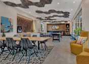 Thumbnail 5 of 28 - the lobby of a building with tables and chairs and large windows